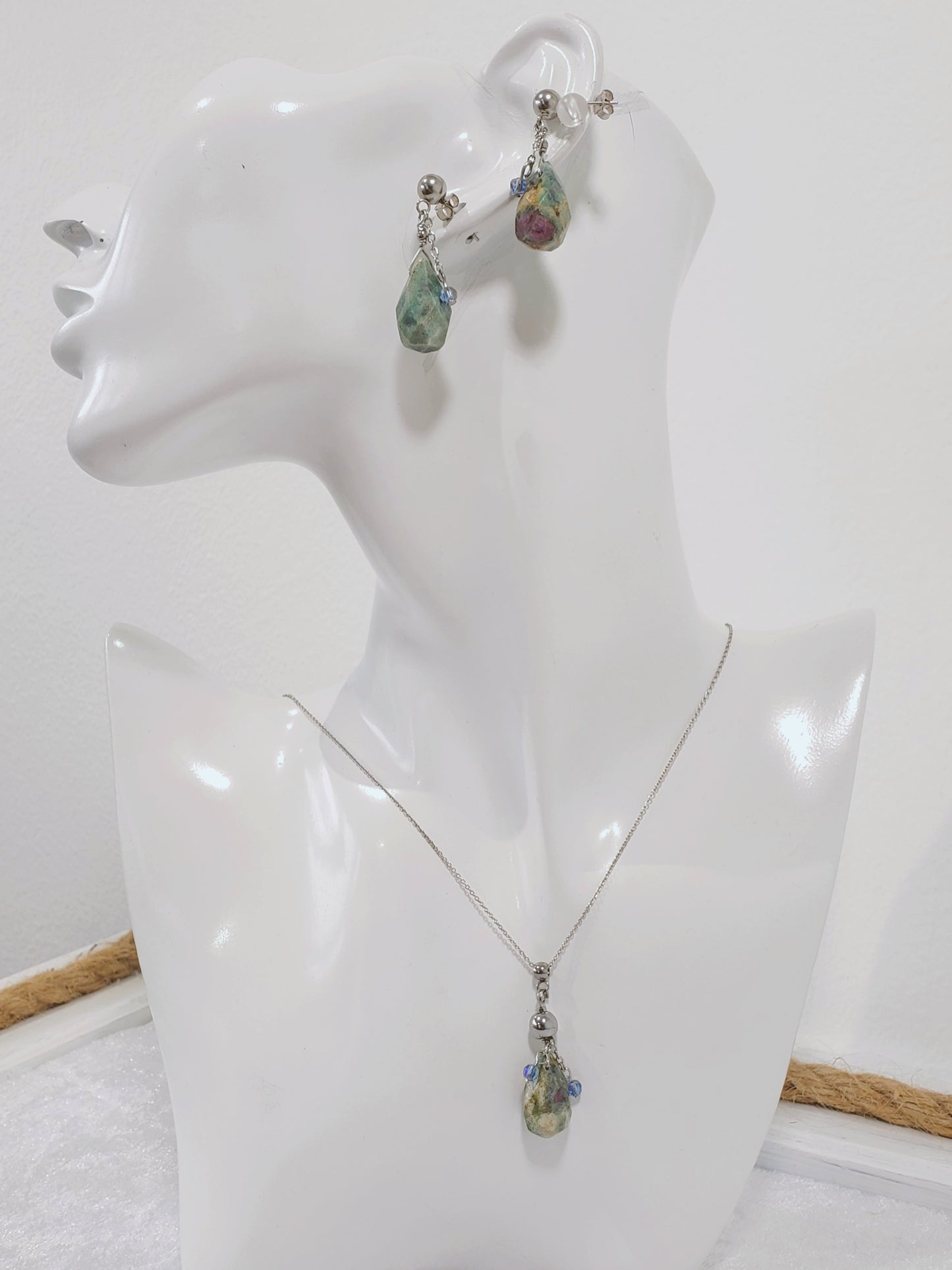 Conjunto de Collar y Aretes de plata 925 presenta una hermosa piedra de Rubí junto con un delicado cristal Swarovski color Azul claro.