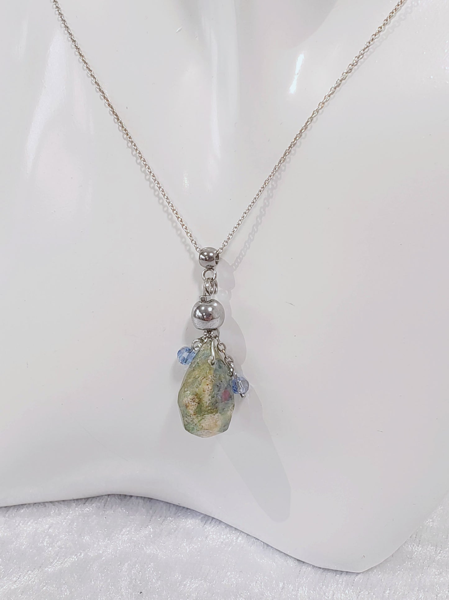 Conjunto de Collar y Aretes de plata 925 presenta una hermosa piedra de Rubí junto con un delicado cristal Swarovski color Azul claro.