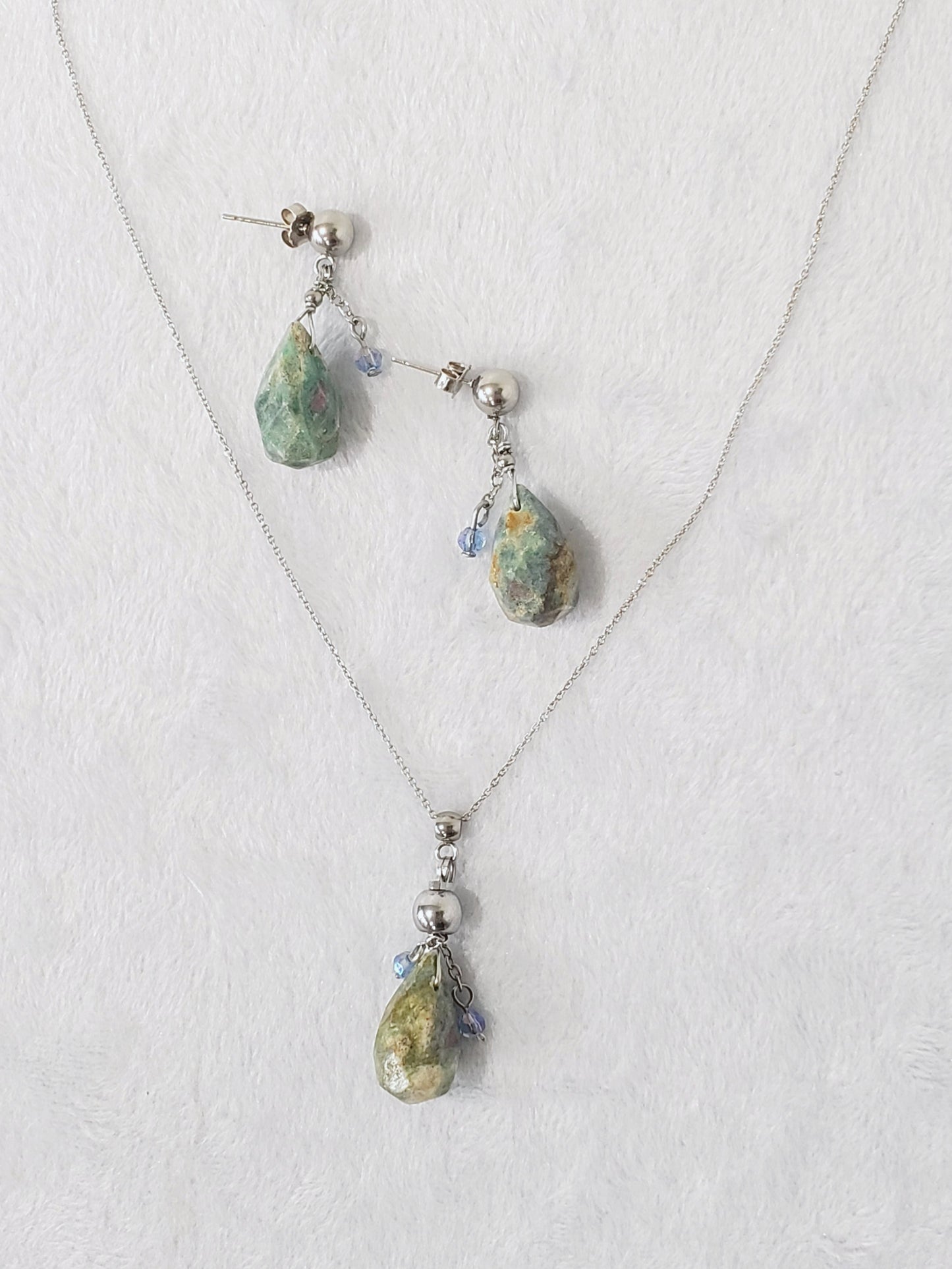 Conjunto de Collar y Aretes de plata 925 presenta una hermosa piedra de Rubí junto con un delicado cristal Swarovski color Azul claro.