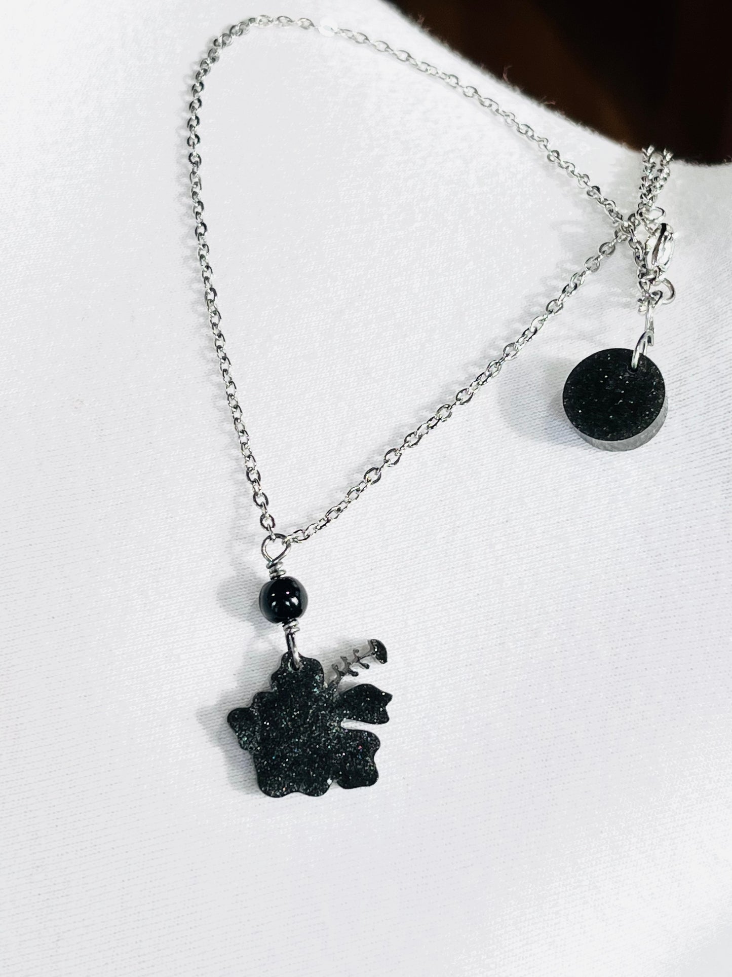 Collar en Acero Inoxidable , con Colgante en Resina color negro Flor Maga - K.Beloved LLC