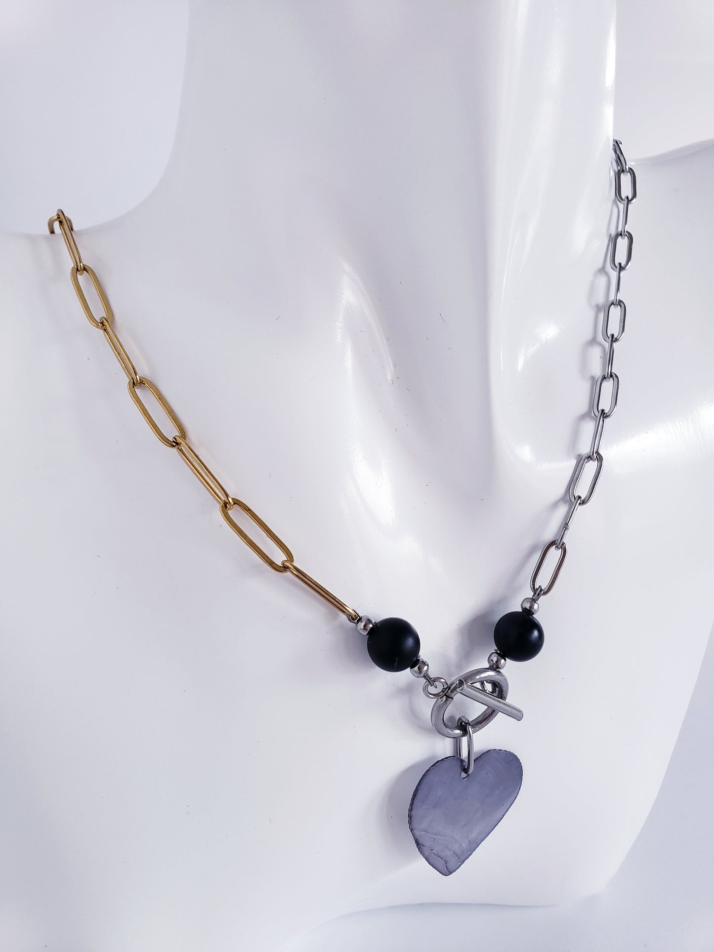 Moderno Collar combina el Color Dorado y el Plata, junto con llamativa piedra preciosa de ónix negro y Un Colgante Capiz en Forma de Corazon…