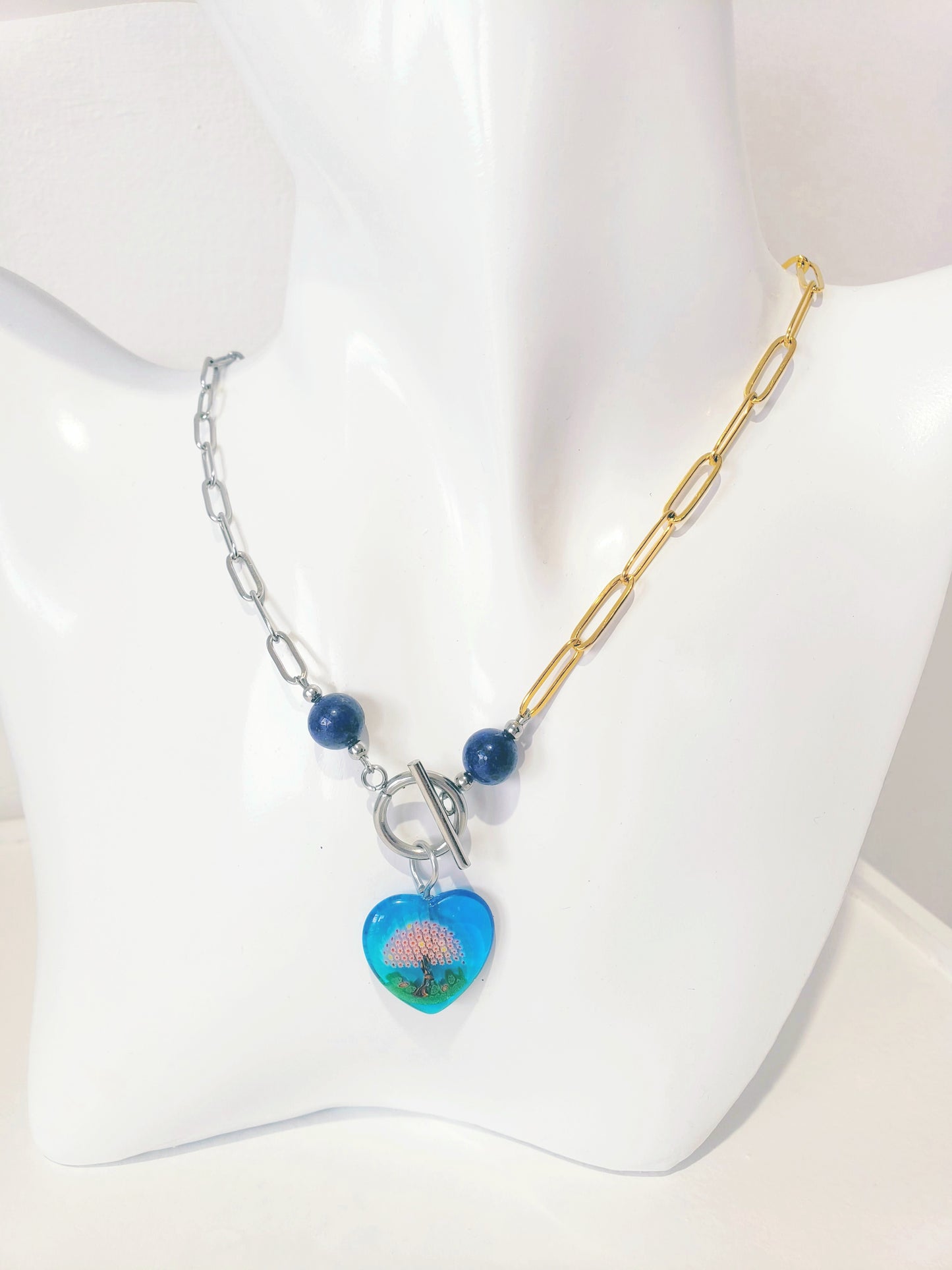 Moderno Collar combina el Color Dorado y el Plata, junto con llamativa piedra preciosa de Lapis Azul   y Un Colgante en Forma de Corazon en Millefiori Glass …