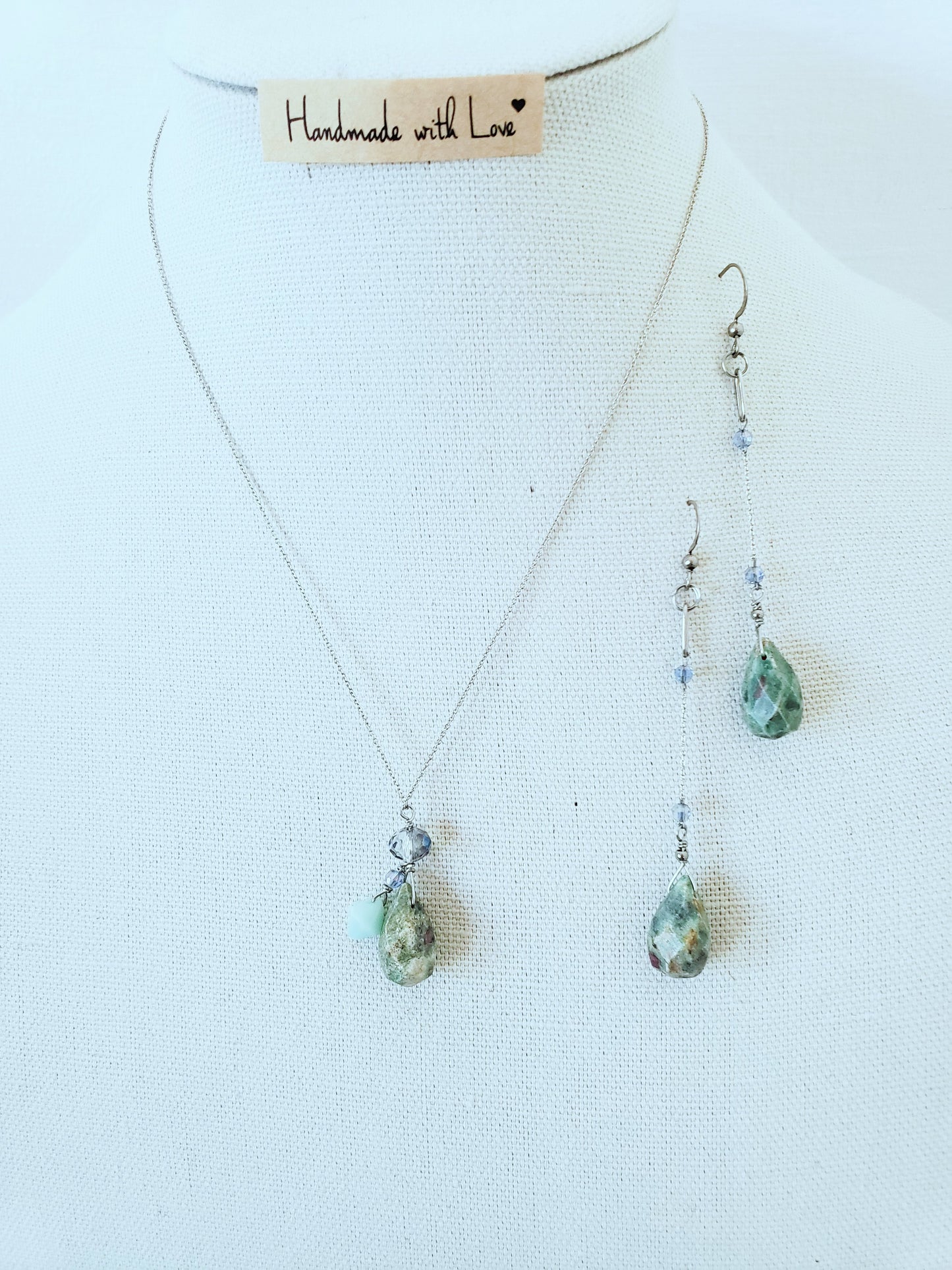 Conjunto de Collar y Aretes de plata 925 presenta una hermosa piedra de Rubí junto con un delicado cristal Swarovski color Azul claro.
