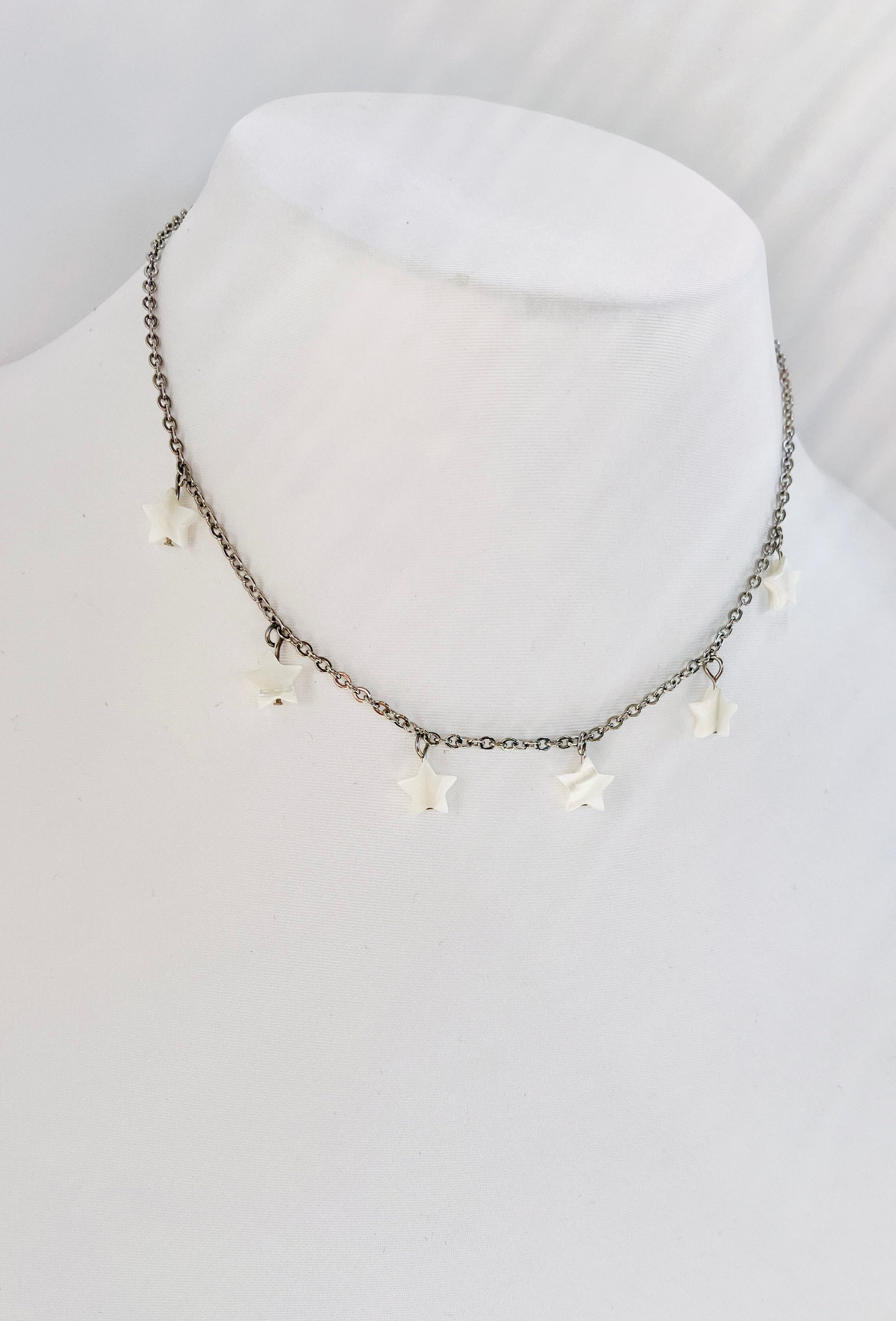 Este delicado collar en Acero Inoxidable con Estrellas de Concha Blancas , aporta un toque chic y modern - K.Beloved LLC