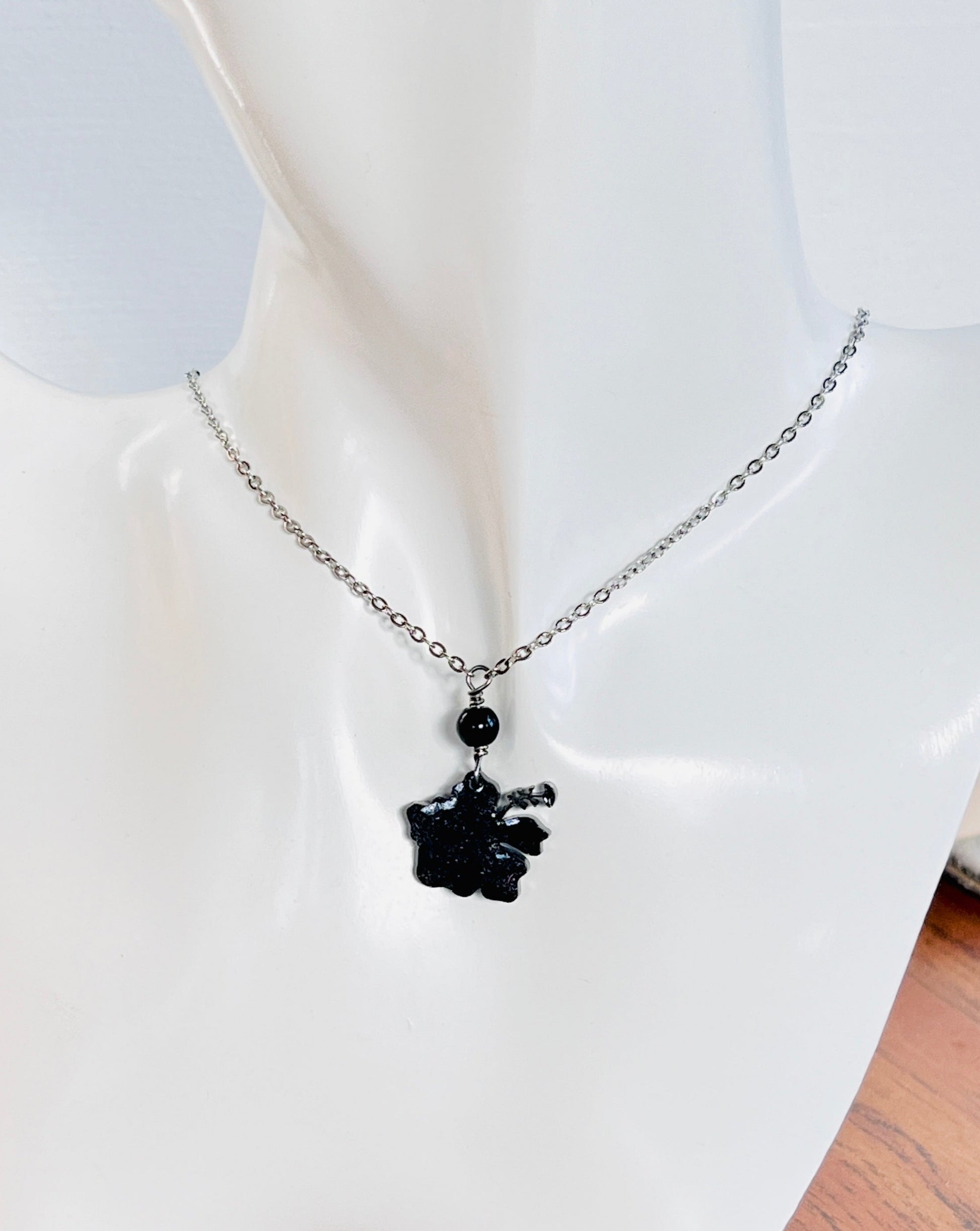 Collar en Acero Inoxidable , con Colgante en Resina color negro Flor Maga - K.Beloved LLC