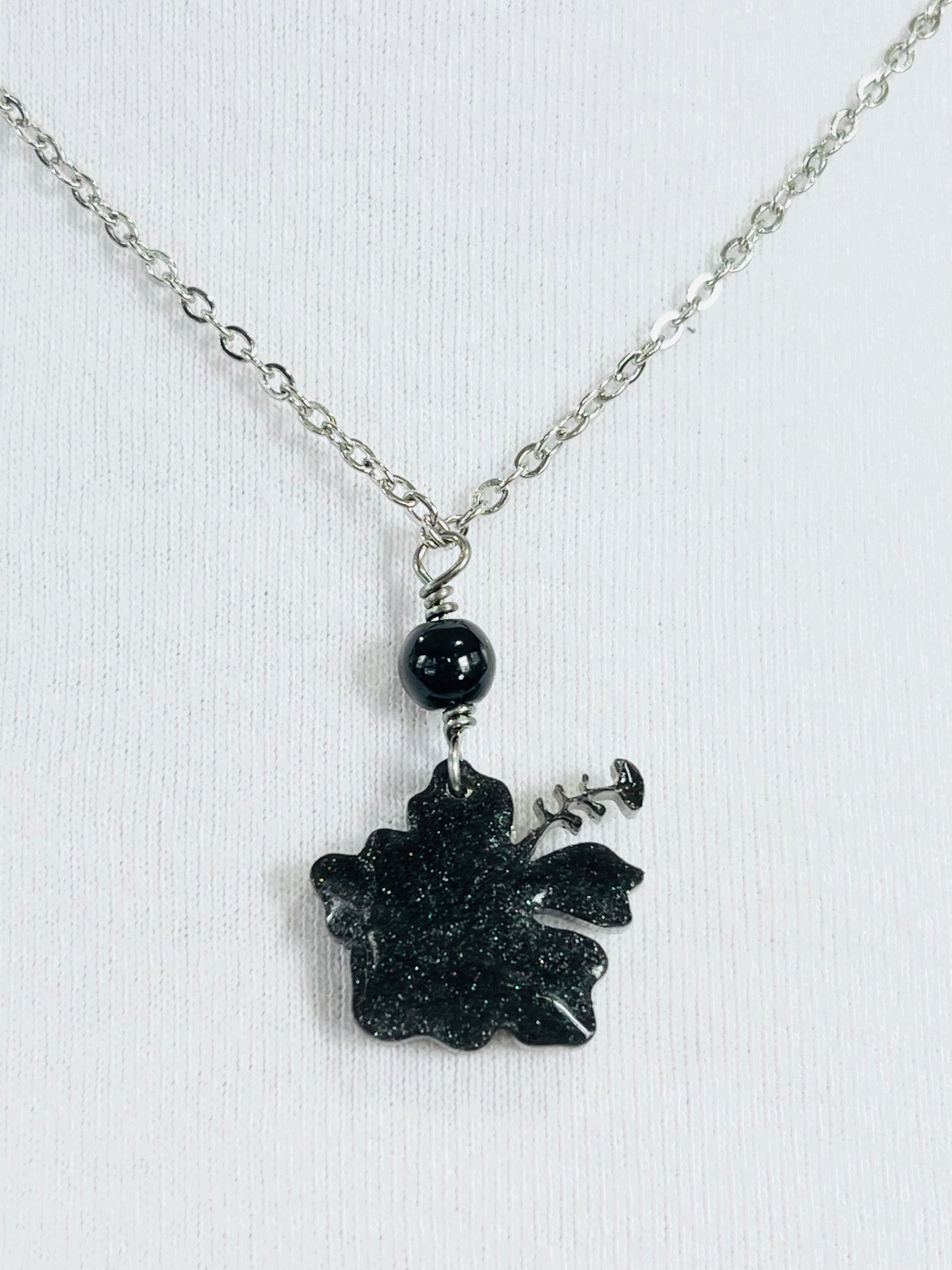 Collar en Acero Inoxidable , con Colgante en Resina color negro Flor Maga - K.Beloved LLC